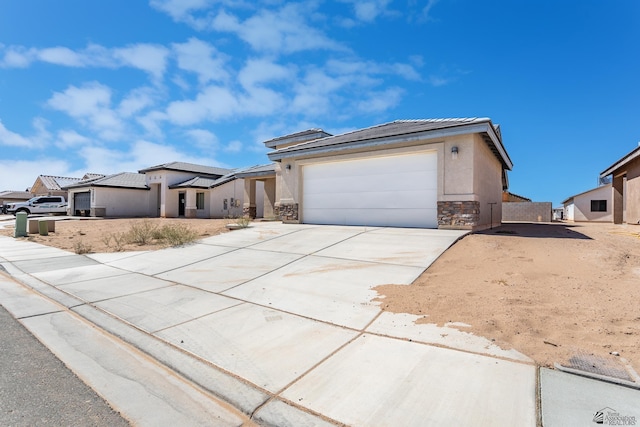 3830 E Jett St, San Luis, AZ 85336 - view of front of home with stone siding, concrete driveway, stucco siding, a tiled roof, and an attached garage
