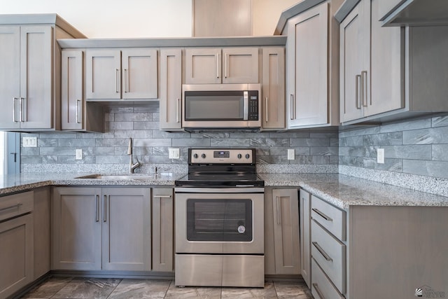3830 E Jett St, San Luis, AZ 85336 - kitchen with appliances with stainless steel finishes, a sink, tasteful backsplash, and light stone countertops
