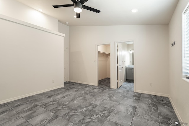 3830 E Jett St, San Luis, AZ 85336 - unfurnished bedroom with a walk in closet, marble look tile flooring, baseboards, a closet, and recessed lighting
