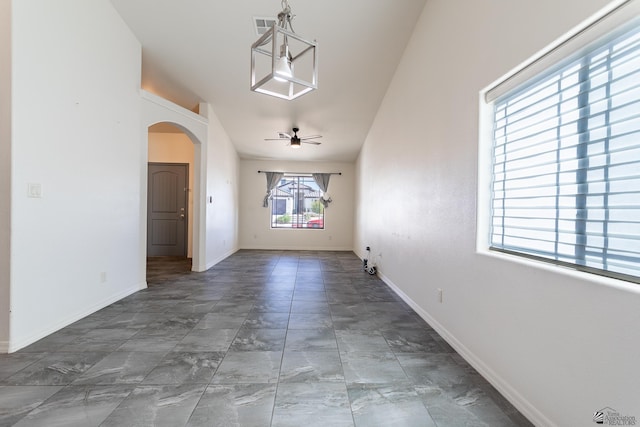 3830 E Jett St, San Luis, AZ 85336 - unfurnished dining area featuring arched walkways, baseboards, and a ceiling fan