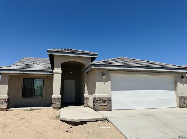3830 E Jett St, San Luis, AZ 85336 - single story home with stone siding, a tile roof, stucco siding, concrete driveway, and an attached garage