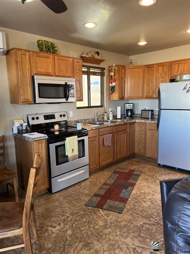 kitchen featuring a wall mounted air conditioner, ceiling fan, sink, and stainless steel appliances