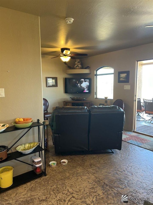 living room with ceiling fan and a textured ceiling