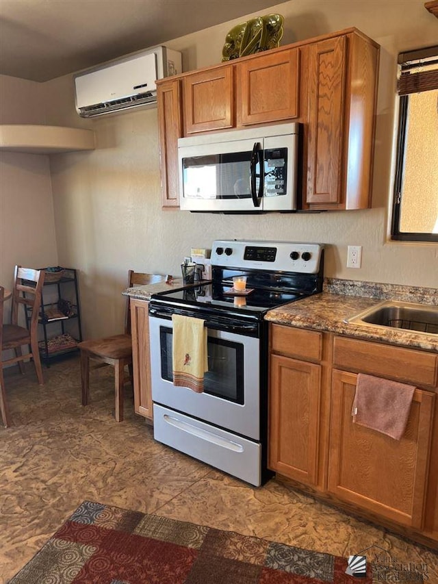 kitchen with a wall mounted AC, sink, and stainless steel appliances