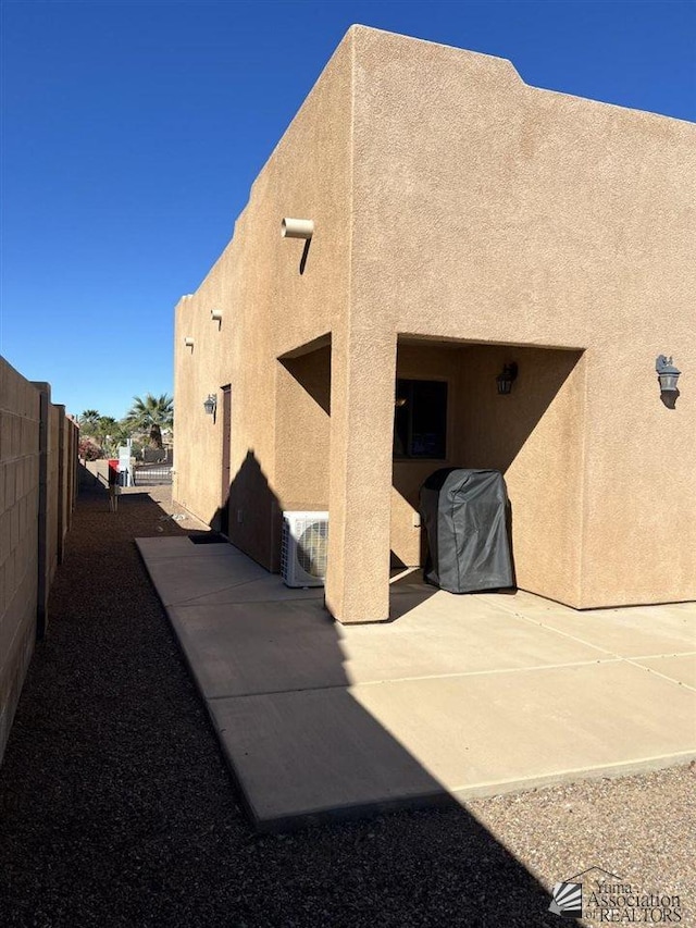 rear view of property with ac unit and a patio area