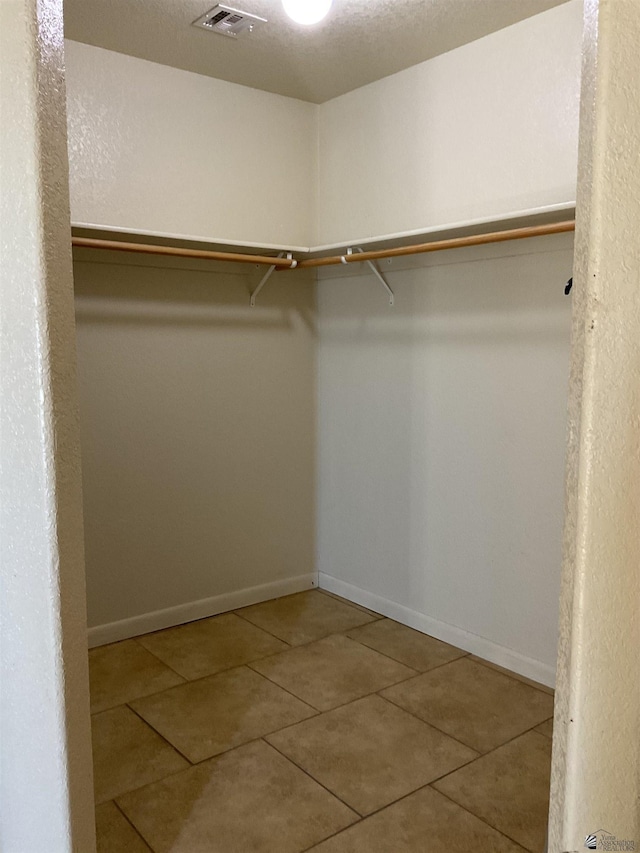 spacious closet with tile patterned floors and visible vents