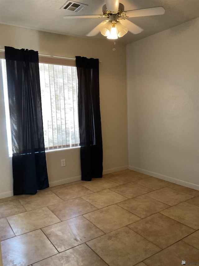 unfurnished room featuring a ceiling fan, baseboards, visible vents, and light tile patterned floors