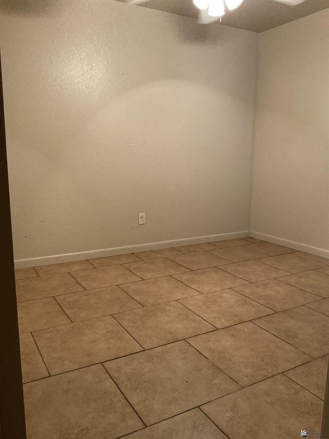 spare room with baseboards, a ceiling fan, and light tile patterned floors