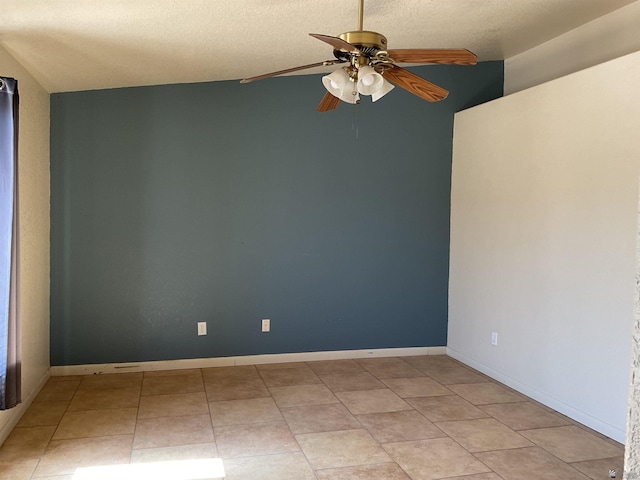 empty room with a textured ceiling, ceiling fan, and light tile patterned flooring