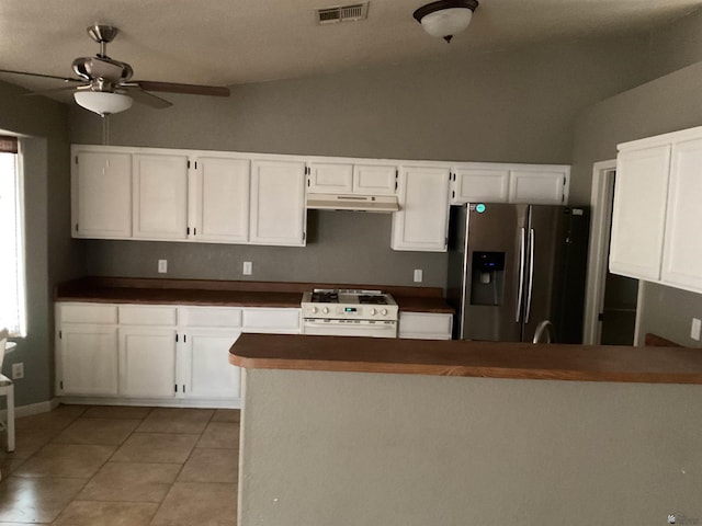 kitchen with a ceiling fan, stainless steel refrigerator with ice dispenser, visible vents, white gas range oven, and under cabinet range hood
