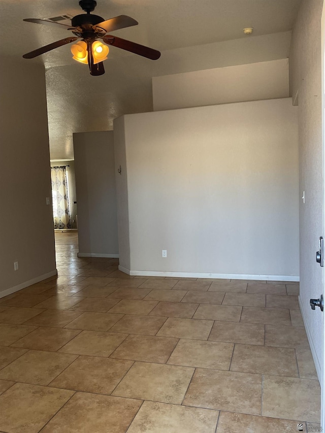 unfurnished room featuring ceiling fan, baseboards, and a towering ceiling