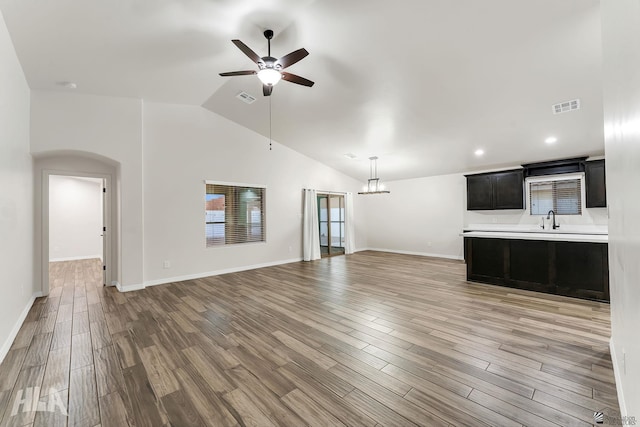 12616 E 49th Dr, Yuma, AZ 85367 - unfurnished living room featuring visible vents, light wood finished floors, a sink, and ceiling fan with notable chandelier