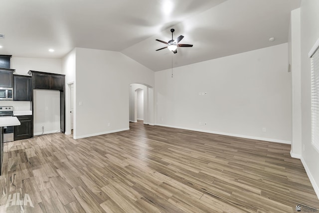 12616 E 49th Dr, Yuma, AZ 85367 - unfurnished living room featuring ceiling fan, light wood-style floors, arched walkways, baseboards, and lofted ceiling