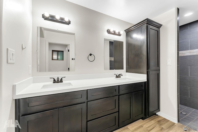 12616 E 49th Dr, Yuma, AZ 85367 - bathroom featuring double vanity, a tile shower, a sink, and wood finished floors