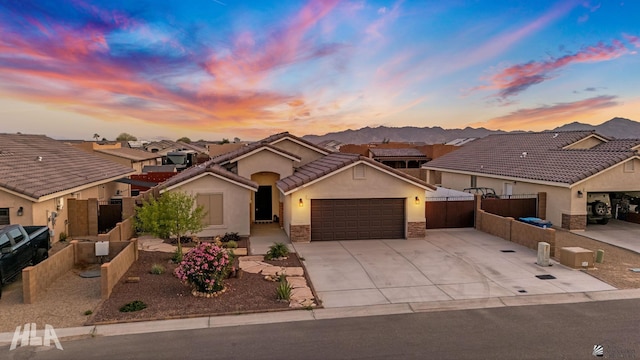 12616 E 49th Dr, Yuma, AZ 85367 - view of front of home featuring driveway, fence, an attached garage, stone siding, and stucco siding