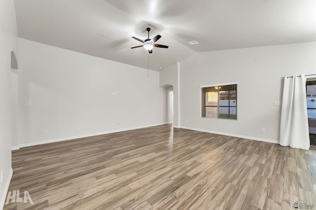 12616 E 49th Dr, Yuma, AZ 85367 - unfurnished living room with light wood-style floors, arched walkways, vaulted ceiling, and a ceiling fan