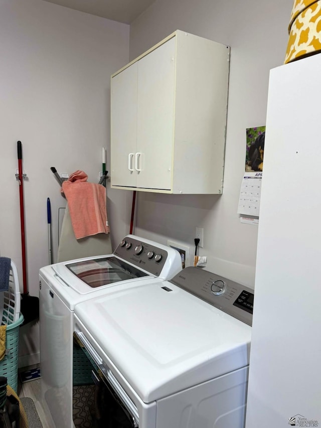 washroom featuring cabinet space and separate washer and dryer