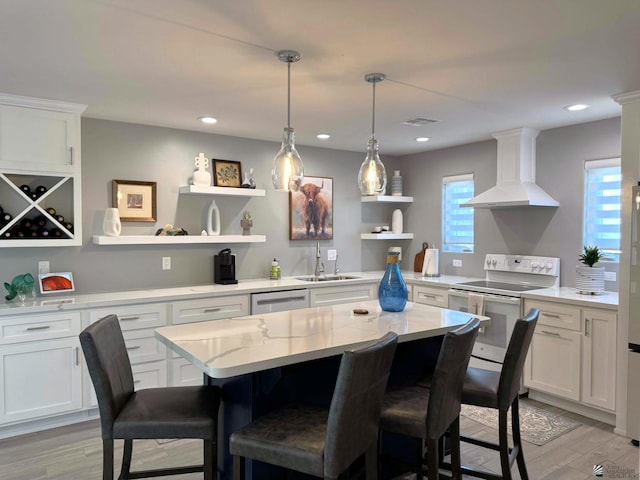 kitchen with open shelves, wall chimney exhaust hood, white range with electric stovetop, and white cabinetry