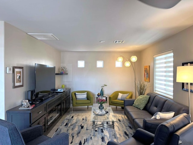 living room featuring visible vents, plenty of natural light, and light wood-style floors