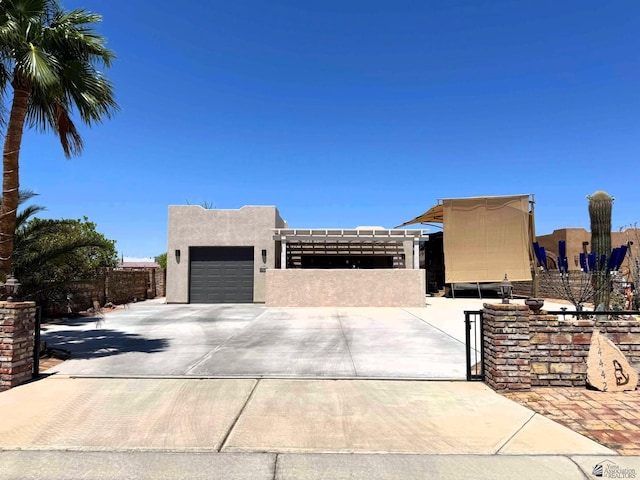 view of front of property with fence, stucco siding, concrete driveway, and a garage