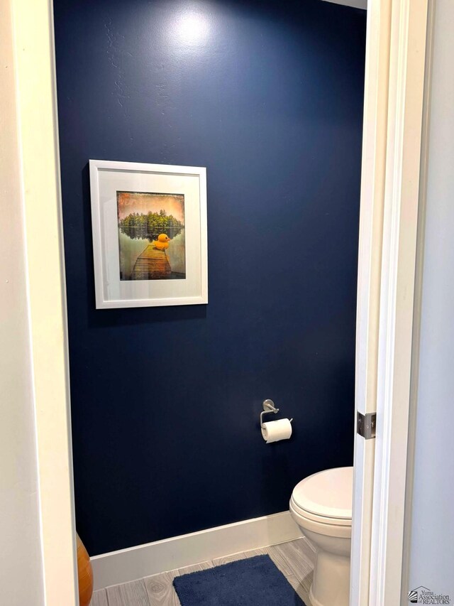 bathroom featuring baseboards and toilet