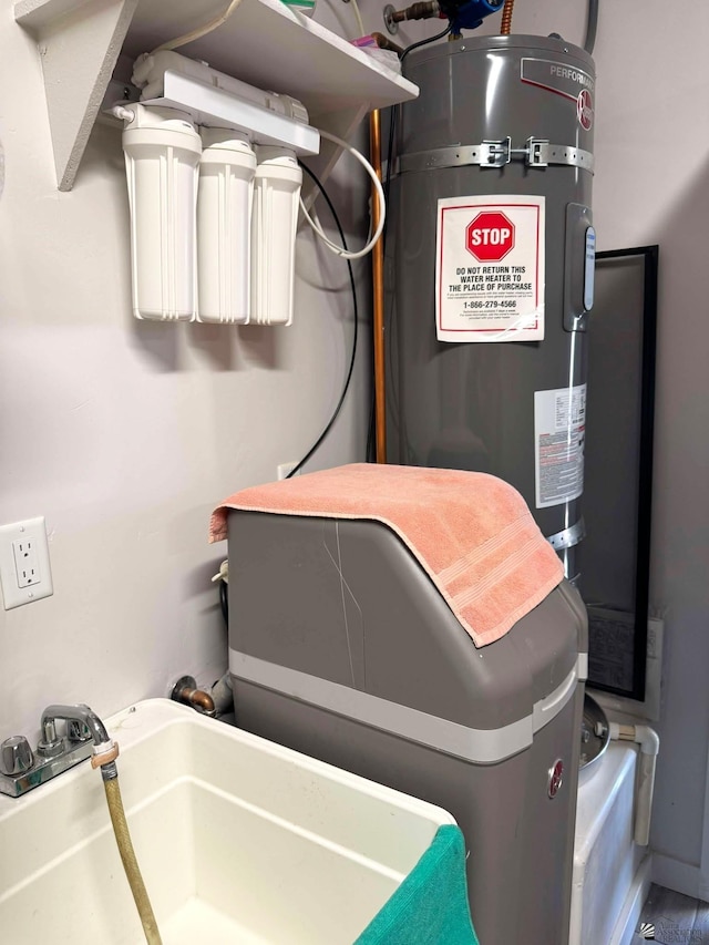 utility room with a sink and strapped water heater