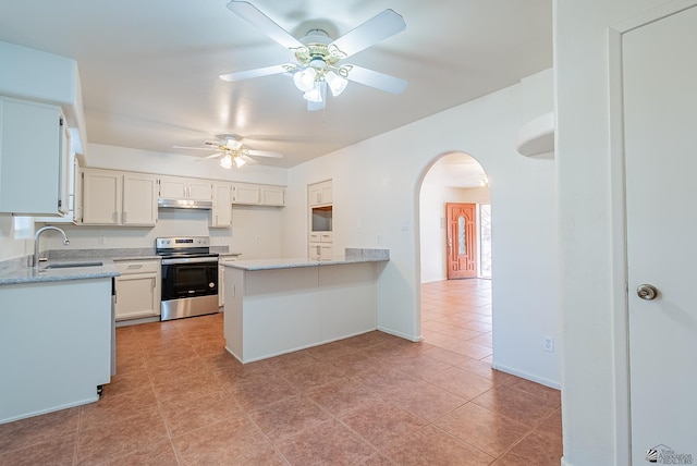 kitchen featuring electric range, a peninsula, arched walkways, under cabinet range hood, and a sink