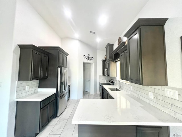 8756 E 41st St, Yuma, AZ 85365 - kitchen with appliances with stainless steel finishes, lofted ceiling, backsplash, a peninsula, and a sink