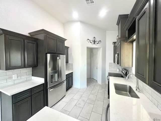 8756 E 41st St, Yuma, AZ 85365 - kitchen with stainless steel appliances, a sink, backsplash, and light marble finish floors