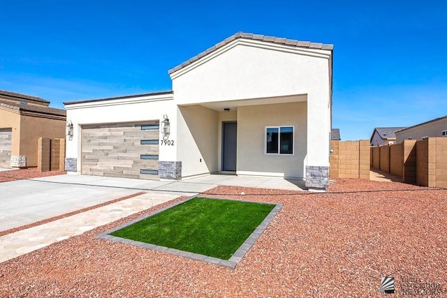 modern home with concrete driveway, an attached garage, fence, and stucco siding