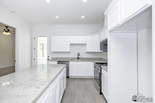 kitchen featuring stainless steel appliances, recessed lighting, white cabinetry, and a sink
