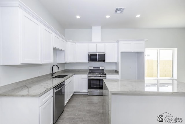 kitchen with visible vents, a sink, white cabinets, and stainless steel appliances