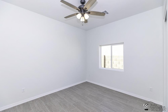 empty room featuring baseboards, visible vents, and ceiling fan