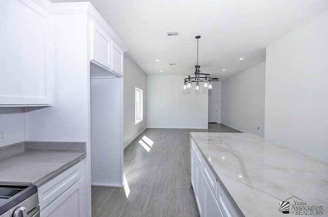 unfurnished dining area with recessed lighting, wood finished floors, a chandelier, and visible vents