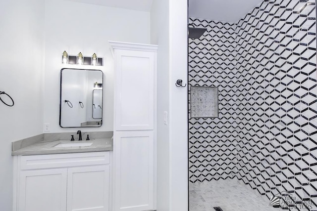full bath with tiled shower and vanity