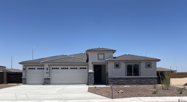 3672 E Elliott Way Unit 3672E, Elliott Way, Yuma, AZ 85365 - prairie-style home featuring fence, concrete driveway, an attached garage, stone siding, and stucco siding