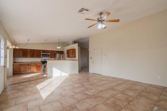 interior space with a center island, vaulted ceiling, hanging light fixtures, ceiling fan, and stainless steel appliances