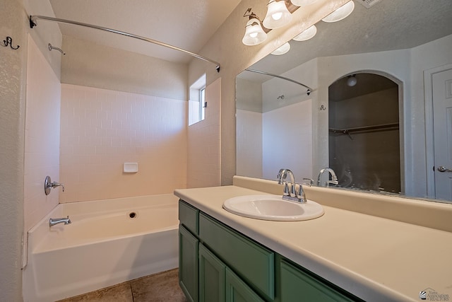 bathroom featuring tile patterned floors, shower / bathing tub combination, a textured ceiling, and vanity