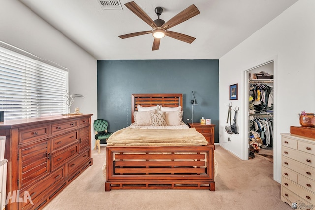 carpeted bedroom with ceiling fan, a spacious closet, and a closet