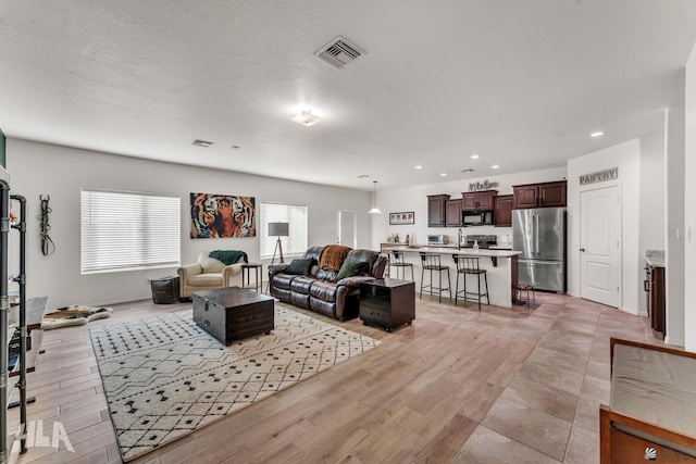 living room featuring a textured ceiling and light wood-type flooring