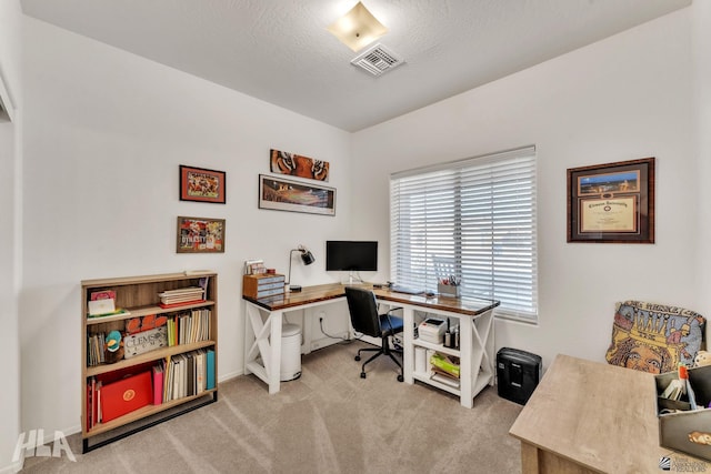 carpeted home office with a textured ceiling