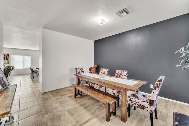 dining room featuring a textured ceiling and light wood-type flooring