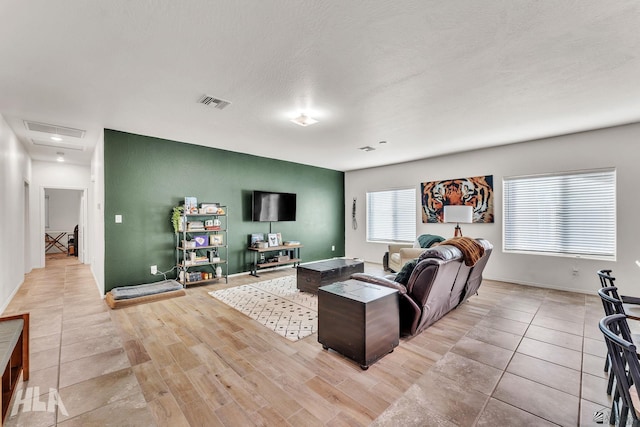 living room with a textured ceiling and light hardwood / wood-style floors