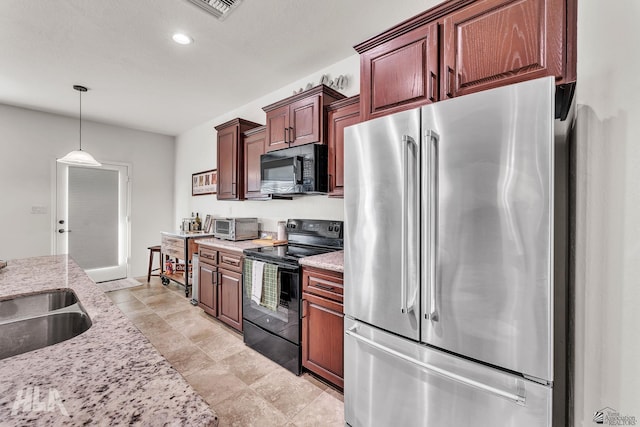 kitchen with sink, pendant lighting, light stone counters, and black appliances