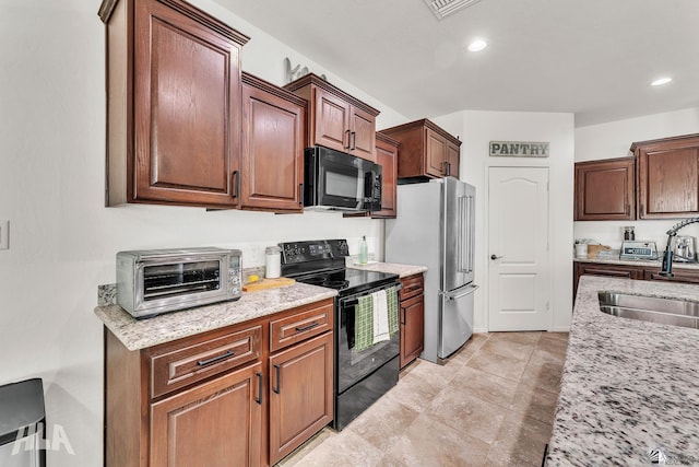 kitchen with light stone countertops, sink, and black appliances