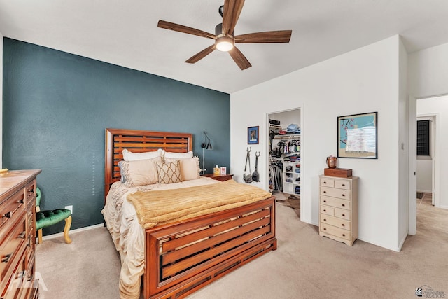 carpeted bedroom with a spacious closet, ceiling fan, and a closet