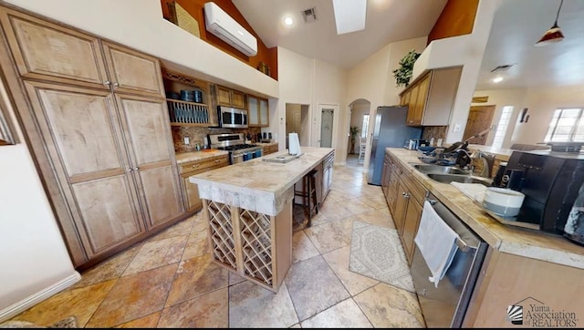 kitchen with visible vents, arched walkways, a sink, light countertops, and stainless steel appliances