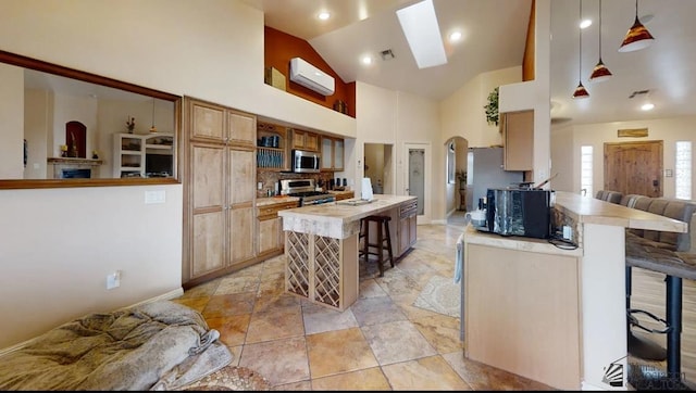 kitchen featuring a fireplace, a breakfast bar, light countertops, a wall unit AC, and stainless steel appliances