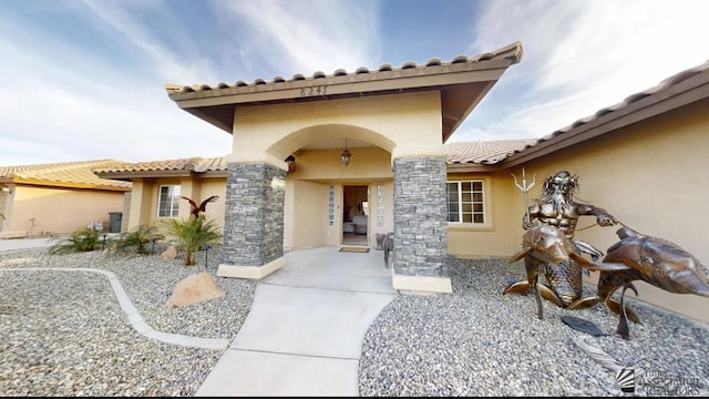 doorway to property with a tiled roof and stucco siding