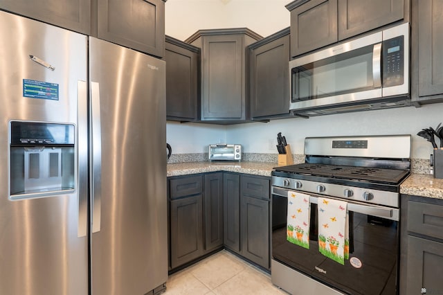 11602 E 33rd St, Yuma, AZ 85367 - kitchen with a toaster, light tile patterned floors, light stone countertops, and stainless steel appliances